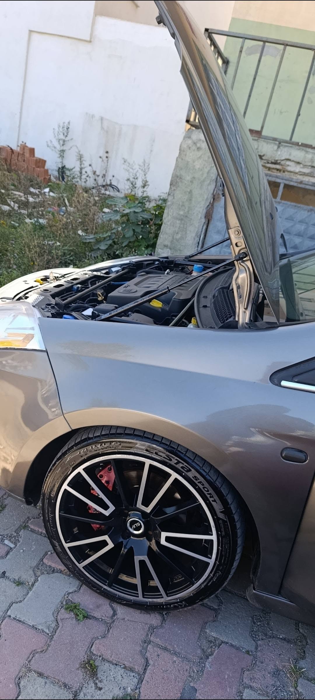Audi Q7 kaput amortisörü Bravo orijinal kaput civatasına takılı — motor bölmesi
